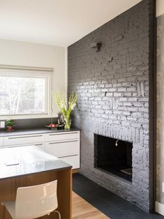 a kitchen area with a fireplace, counter top and chairs in front of the stove