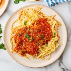 a plate of spaghetti with sauce and parsley