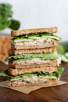 a close up of a sandwich with lettuce and tomato on it, in front of the words tuna cucumber sandwich healthy quick and easy