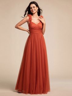 a woman in an orange dress posing for the camera