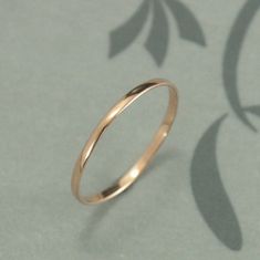 a gold wedding ring sitting on top of a sheet of paper with leaves drawn on it