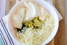 a white bowl filled with different types of food on top of a wooden cutting board