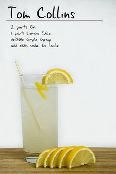 a tall glass filled with lemonade next to slices of lemon on top of a wooden table