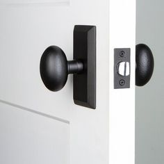 an open door with a black handle and knobs on it's front door