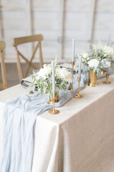 the table is set with candles, flowers and napkins for an elegant wedding reception