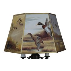 a lamp that is on top of a stand with two ducks in the sky above it