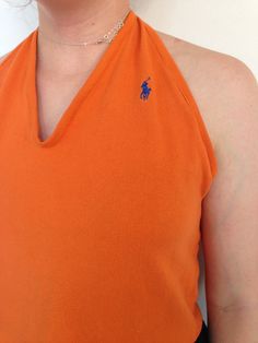 This reworked vintage Ralph Lauren orange halter top is perfect for the summer! Cropped below the belly button, this shirt is backless so you can perfect your glowing tan while looking glamorous *and* being environmentally friendly by shopping vintage! What better combination could there be?  ONLY ONE. UTTERLY UNIQUE. Length from shoulder to hem: 17 inches Fitted V-neck Tops For Beach Season, Orange Stretch Summer Tops, Orange Short Sleeve Crop Top For Summer, Fitted Backless Tops For Beachwear, Orange Stretch Crop Top For Summer, Orange Summer Crop Tank Top, Orange Cropped Tops For Vacation, Orange Cropped Top For Beach, Fitted Backless Summer Tops