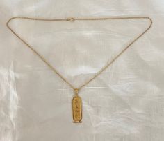 -14K Gold Hieroglyphics Cartouche Pendant Necklace- Elegant 14K gold necklace featuring a cartouche pendant inscribed with hieroglyphics that include an owl, falcon, eye, and feathers. Signature on the back of pendant is unreadable but the chain is signed "14K Italy". Excellent Condition Chain measures 51cm  Pendant measures 5.5cm L x 1.25cm W Free Priority Mail Shipping Spiritual Gold Necklace With Figaro Chain, Spiritual Jewelry Pendant With Figaro Chain, Yellow Gold Ankh Necklace, Cartouche Necklace, Hebrew Tattoo, Egyptian Pendant, Necklace Elegant, 14k Gold Necklace, Necklace Charm