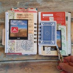 a person holding a pair of scissors in front of a book with pictures on it