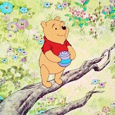 winnie the pooh holding a blue cup on top of a tree branch with flowers in the background