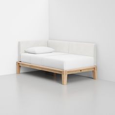 a white bed sitting on top of a wooden frame