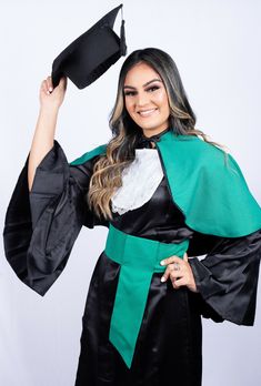 a woman in a graduation gown holding her cap