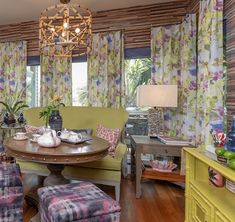 a living room filled with furniture and a chandelier above a wooden dining table