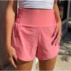 These Highwaisted Running Shorts Are Functional But Still Fashionable, Featuring Scalloped Detail On The Side, Inner Lining, And A Partially Ruched Waistband Detail. Perfect For Heading To The Gym, Running Errands, Or A Casual Day Out. Super Cute And Comfy!, Nwt Pink/Coral Fits True To Size Inner Lining Partially Ruched Waistband Size Small Inseam: 3.75" Self: 88% Nylon, 10% Spandex Inner Lining: 80% Polyester, 20% Spandex Machine Wash Cold | Tumble Dry Low Sporty Bottoms With Built-in Shorts And Athletic Fit, Sporty Running Bottoms With Built-in Shorts, Athletic Bottoms With Built-in Shorts For Sports, Summer Training Bottoms With Built-in Shorts, Sporty High Waist Bottoms With Built-in Shorts, Sporty High-waisted Activewear Shorts With Built-in Shorts, Casual Biker Shorts With Built-in Shorts For Training, Athleisure Bottoms For Gym In Summer, Short Bottoms With Elastic Waistband For Running