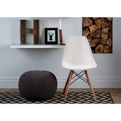 a white chair sitting next to a black and white rug