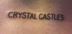 the word crystal castles written in cursive ink on a woman's stomach