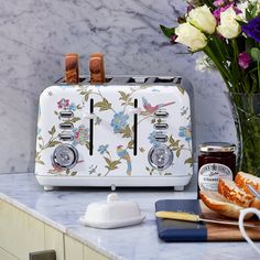 a toaster sitting on top of a counter next to some flowers and other items