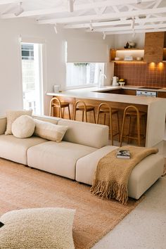 a living room filled with furniture next to a kitchen