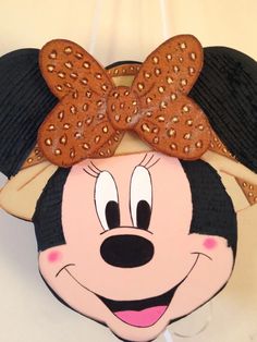 a close up of a minnie mouse head on a white wall with a brown hat