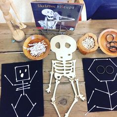 a table topped with wooden bowls filled with different types of items and skeleton cutouts