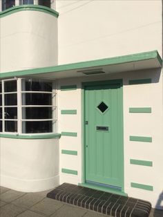 a white building with a green door and window