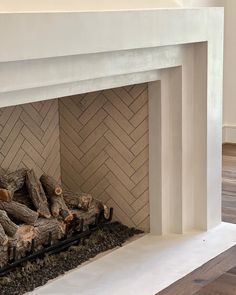 a fire place with logs on top of it and wood in the bottom part of the fireplace