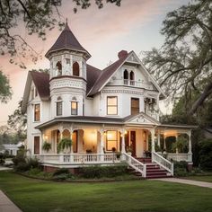 a large white house sitting on top of a lush green field