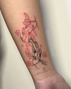 a woman's arm with a koi fish and flowers tattoo design on it