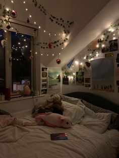 a bedroom with lights strung from the ceiling and stuffed animals on the bed