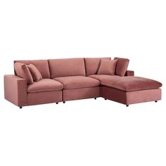 a pink sectional couch with pillows on it