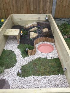 a small garden with rocks, grass and gravel in the center is made to look like an outdoor play area