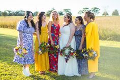 a group of women standing next to each other on top of a grass covered field