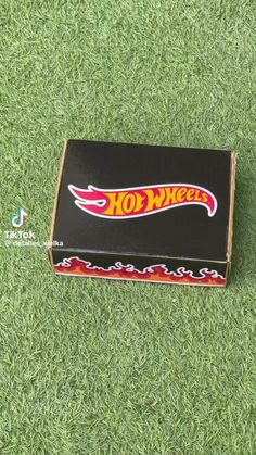 an open box sitting on top of a green grass covered field next to a red and yellow hot dog