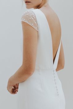 the back of a woman's white dress with buttons on it and an instagram button