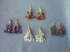 four pairs of beaded earrings on a gray surface