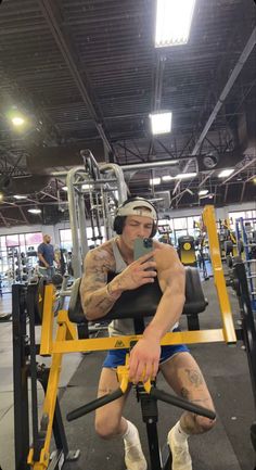 a man sitting on top of a machine in a gym