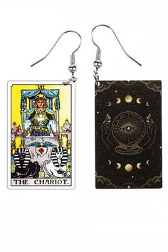 two tarot cards are hanging from earrings on white background, one has an image of the