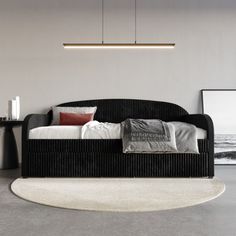 a modern daybed with pillows on it in a room next to a table and chair