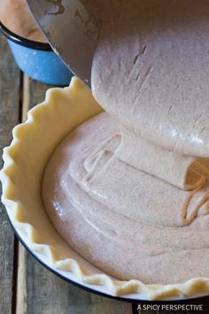 an uncooked pie crust being filled with batter