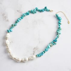 Step into the world of bohemian elegance with our Baroque Pearl Turquoise Necklace , a masterpiece that seamlessly blends the raw beauty of natural stones with the sophistication of pearls. This striking necklace is crafted from high-quality materials, featuring a dynamic combination of turquoise chips and lustrous pearls. The turquoise stones, with their rich blue-green hues and unique veining, offer a vibrant contrast to the smooth, iridescent pearls, each one distinct in its organic shape and glossy finish.   Let this necklace be the centerpiece of your jewelry collection, a symbol of your unique taste and sophisticated charm. DETAILS Plating: 14K Gold Materials: 925 Sterling Silver , Turquoise, Baroque Shell Pearl Measurements: Length: 15.74"(40cm) + Extender: 1.97"(5.0cm) Weight: 32.1 Bohemian Turquoise Necklace For Vacation, Bohemian Blue Necklace With Raw Stone, Elegant Beaded Turquoise Necklace For Beach, Elegant Turquoise Necklace For Beach, Elegant Turquoise Necklace With Round Beads For Beach, Bohemian Howlite Jewelry With Natural Stones, Bohemian Single Strand Jewelry For Vacation, Spiritual Jewelry With Natural Stones For Vacation, Spiritual Natural Stone Jewelry For Vacation