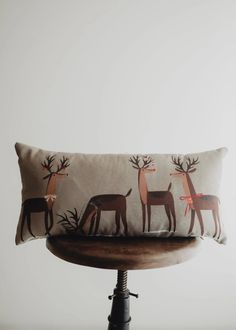 a pillow with deer on it sitting on top of a chair