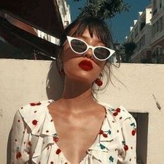 a woman with red lipstick and white sunglasses