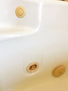 there is a white bathtub with gold faucets