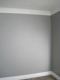 an empty room with gray walls and carpet