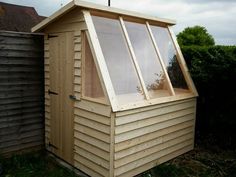 a small wooden shed sitting next to a fence