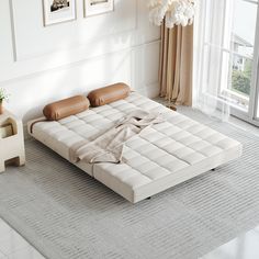 a white bed sitting on top of a carpeted floor next to a vase filled with flowers