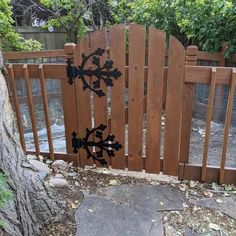 a wooden gate with wrought iron designs on it