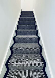 a staircase with black and white chevron carpet