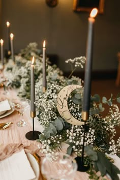 the table is set with candles, plates and napkins for an elegant wedding reception