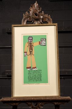 a drawing of a man with a green background and brown frame on top of a wooden table